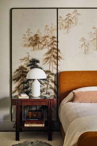 A headboard in Pierre Freys ‘Cheyenne linen is framed by panels of de Gournays ‘Abstract Pines design in the main bedroom.