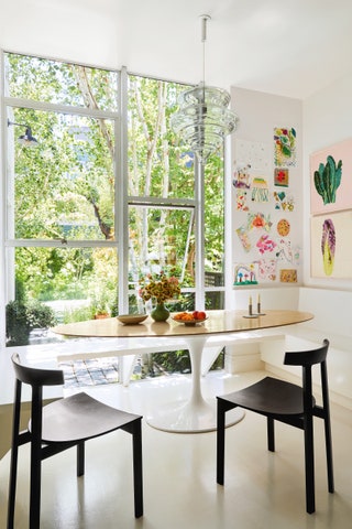 An Eero Saarinen ‘Tulip table base with a bespoke oak top is paired with Bensens ‘Torii dining chairs.