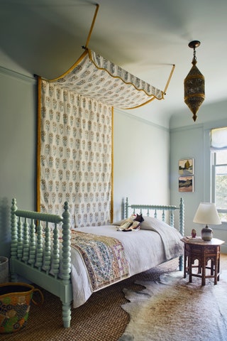 A canopy in Penny Morrisons ‘Kalindi blueyellow linen tones with walls in Farrow  Balls ‘Cromarty in the daughter's bedroom.