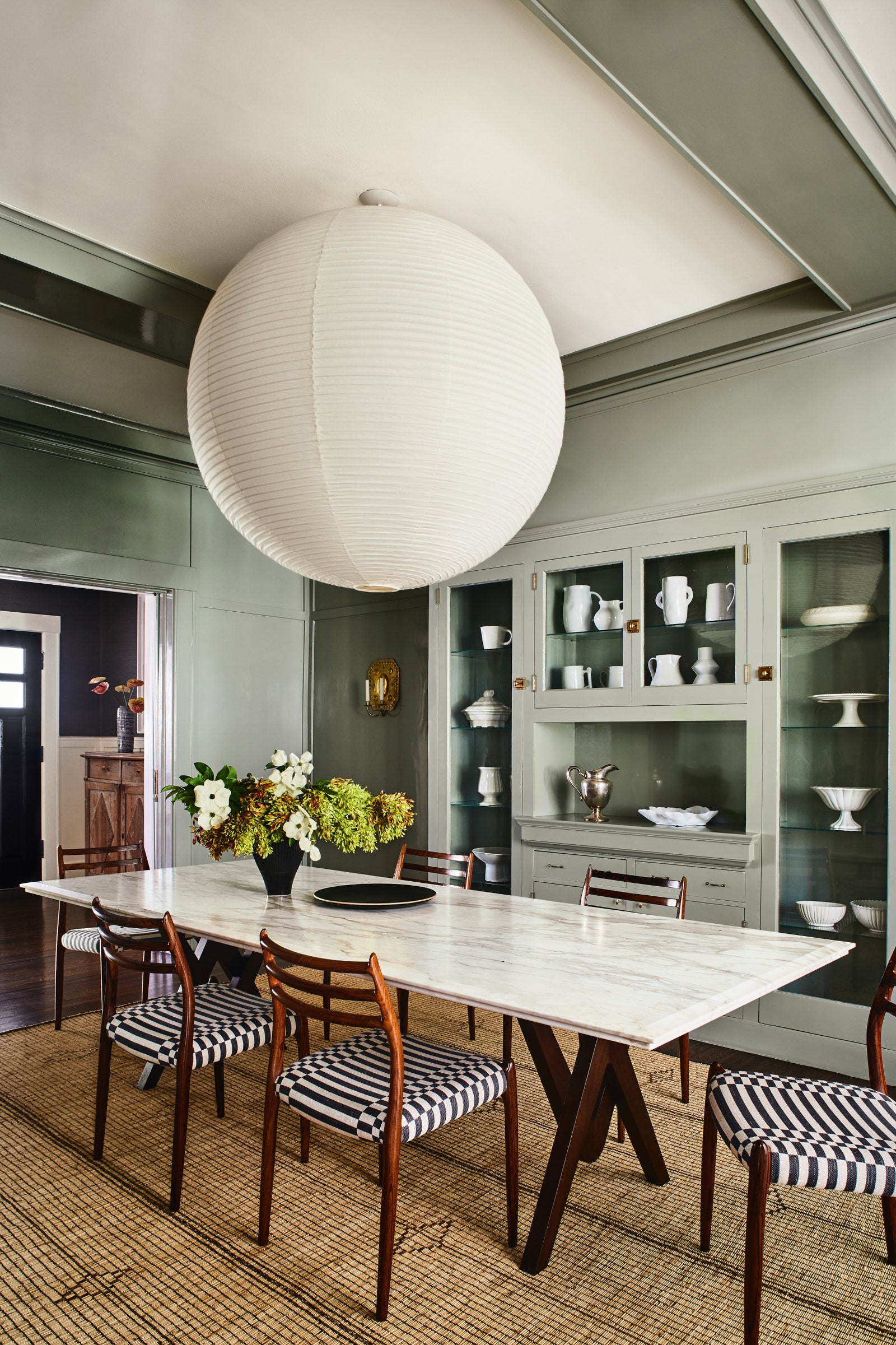 An Isamu Noguchi pendant provides a distinctive focal point above the Pierre Jeanneretinspired table and Niels Otto...